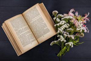 carte deschisă și un buchet de flori de câmp